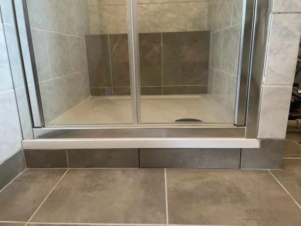 Detail sprchového koutu s průhlednými skleněnými dveřmi